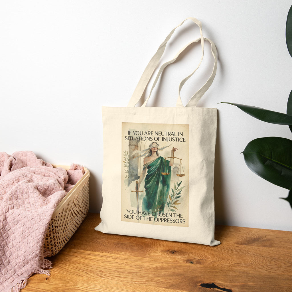 Social justice tote bag featuring Lady Justice and activist slogan "If you are neutral you have chosen the oppressors" printed on fabric.