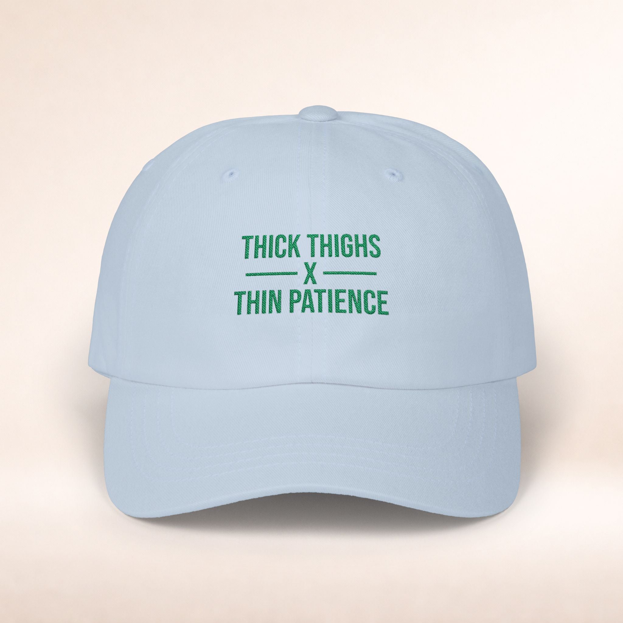 Cotton adjustable dad hat with embroidered "Thick Thighs x Thin Patience" slogan in black on a white cap, stylish casual headwear.