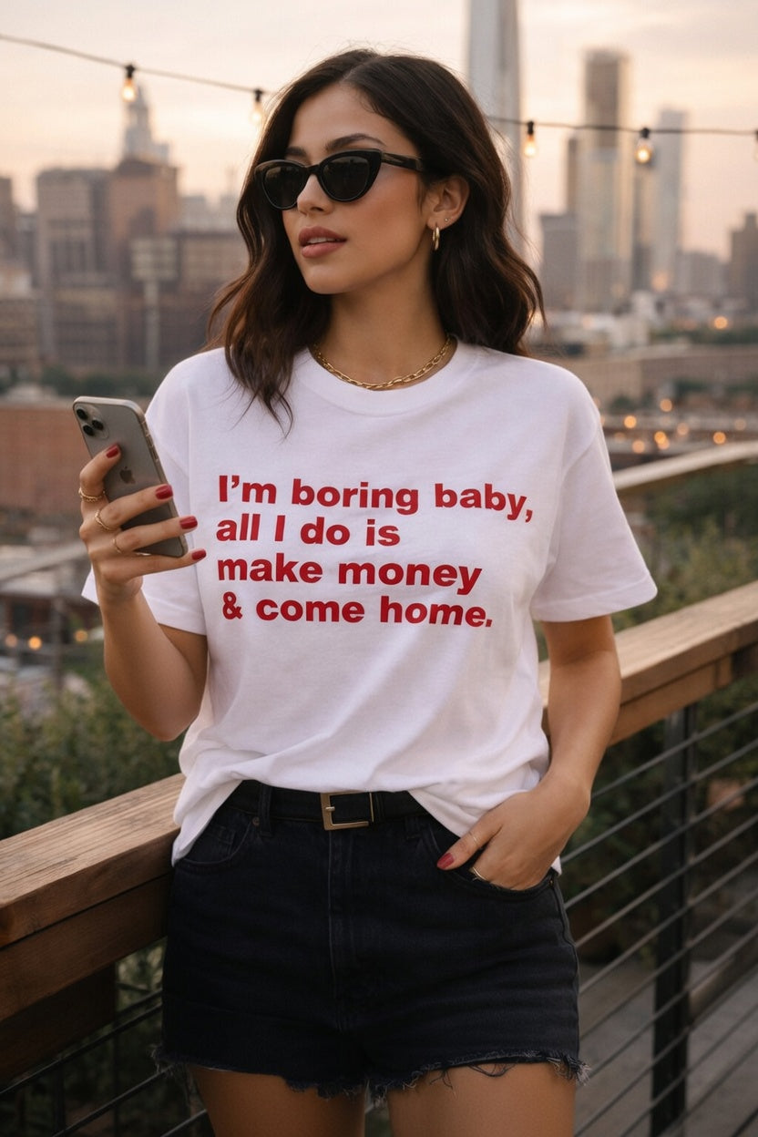 Unisex cotton T-shirt with humorous "I'm Boring Baby All I Do Is Make Money & Come Home" slogan, casual fit, printed by Printify.