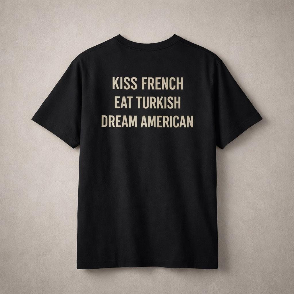 Unisex cotton T-shirt with "Kiss French, Eat Turkish, Dream American" print, featuring a relaxed fit and international design.