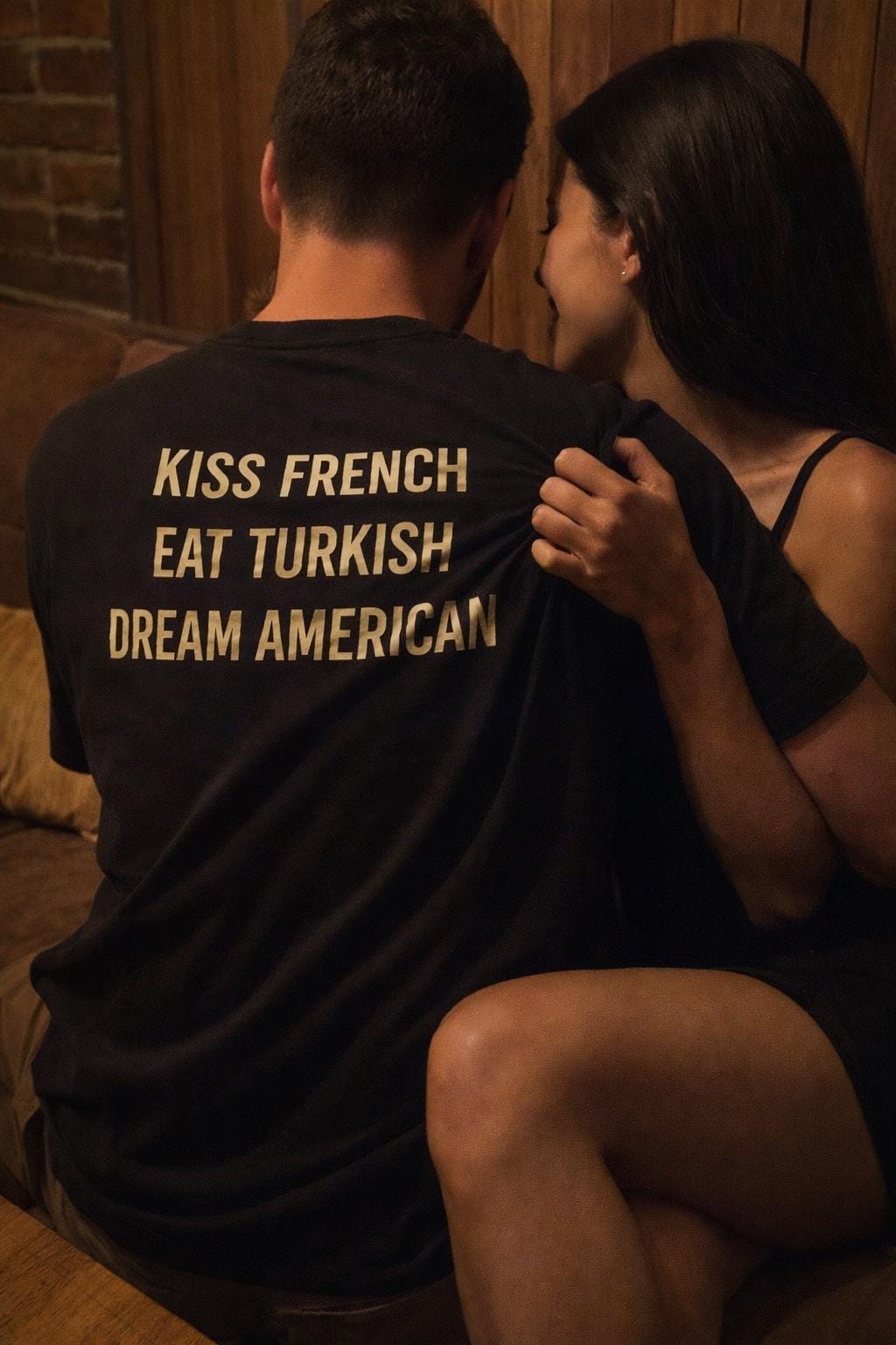 Unisex cotton T-shirt with "Kiss French, Eat Turkish, Dream American" slogan, featuring a casual fit and printed design.