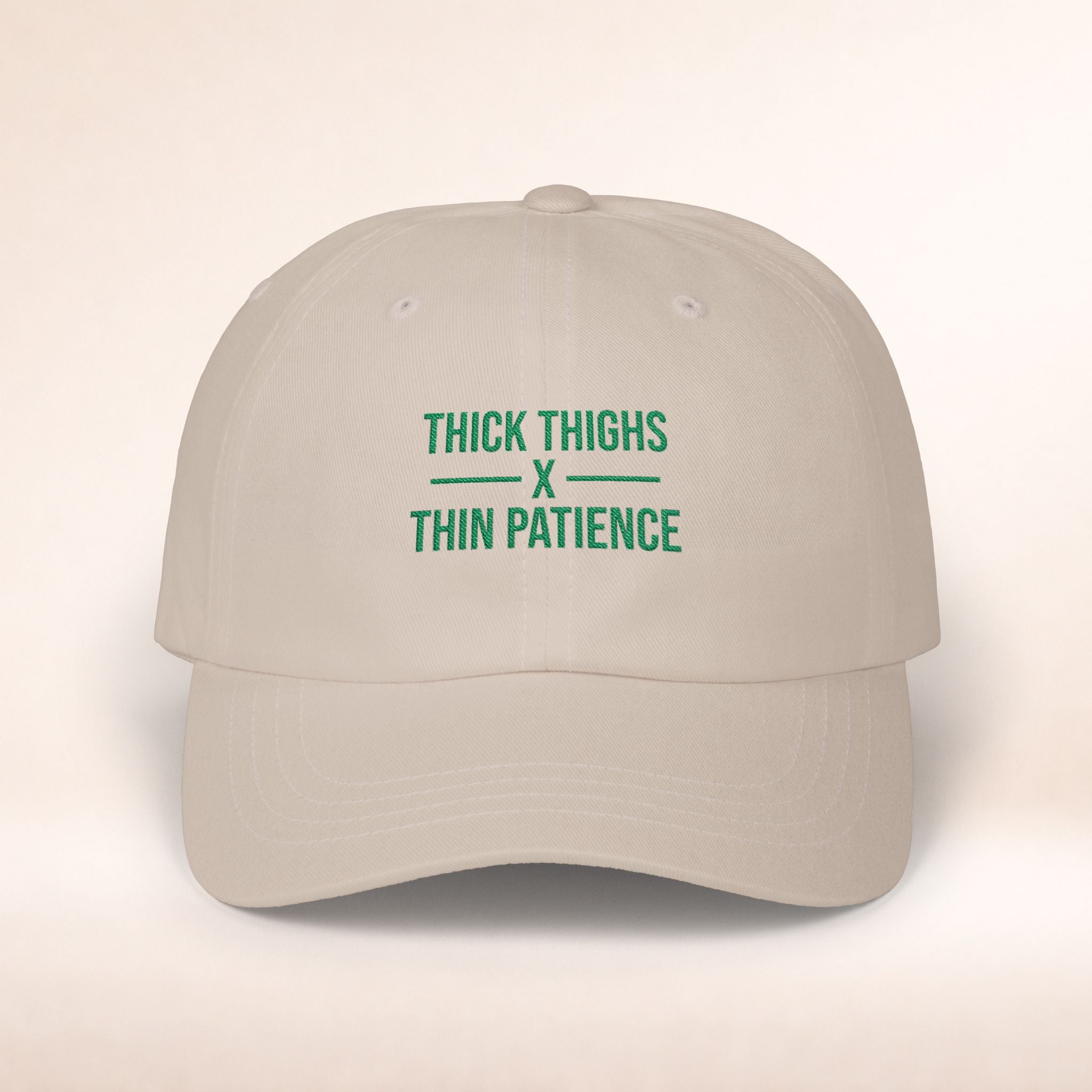 Cotton adjustable dad cap with embroidered "Thick Thighs x Thin Patience" slogan in black lettering on a white hat.